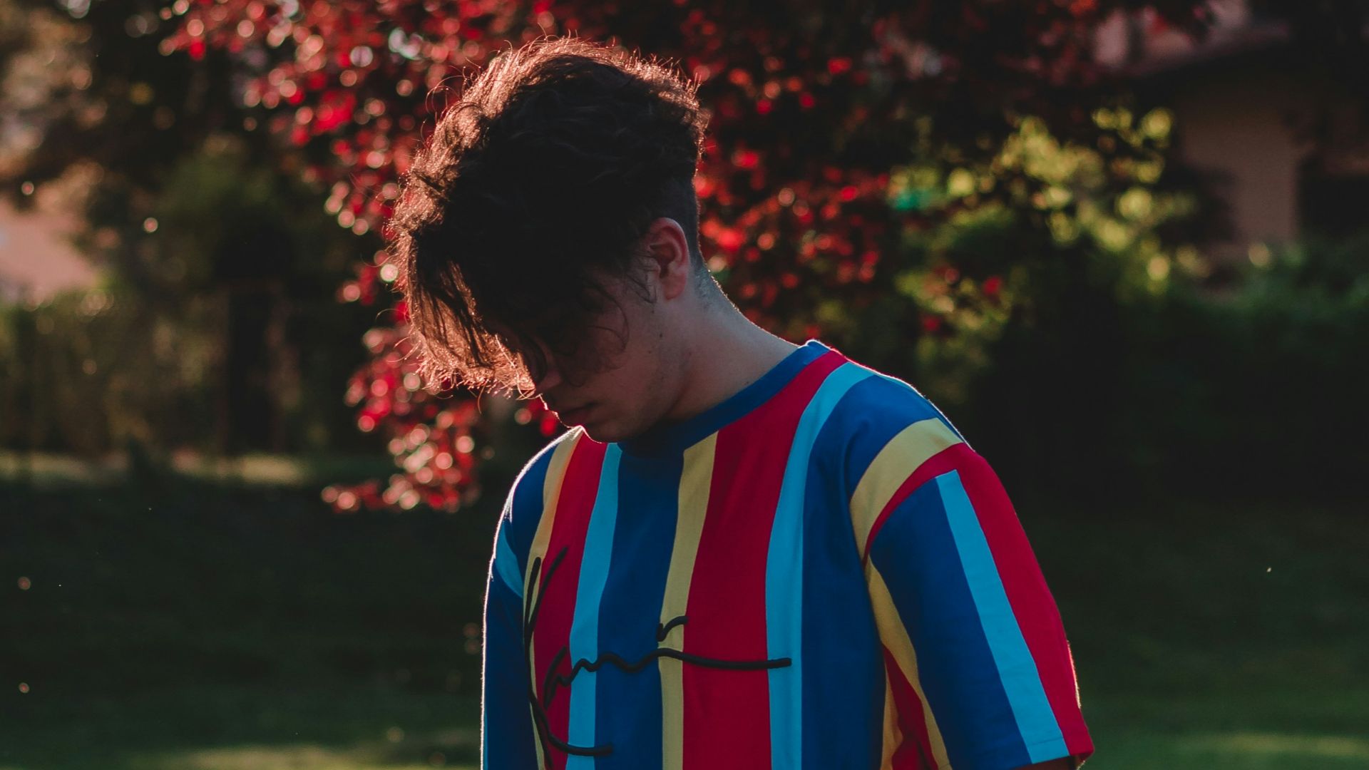 man in red white and blue stripe polo shirt standing near red leaf tree during daytime