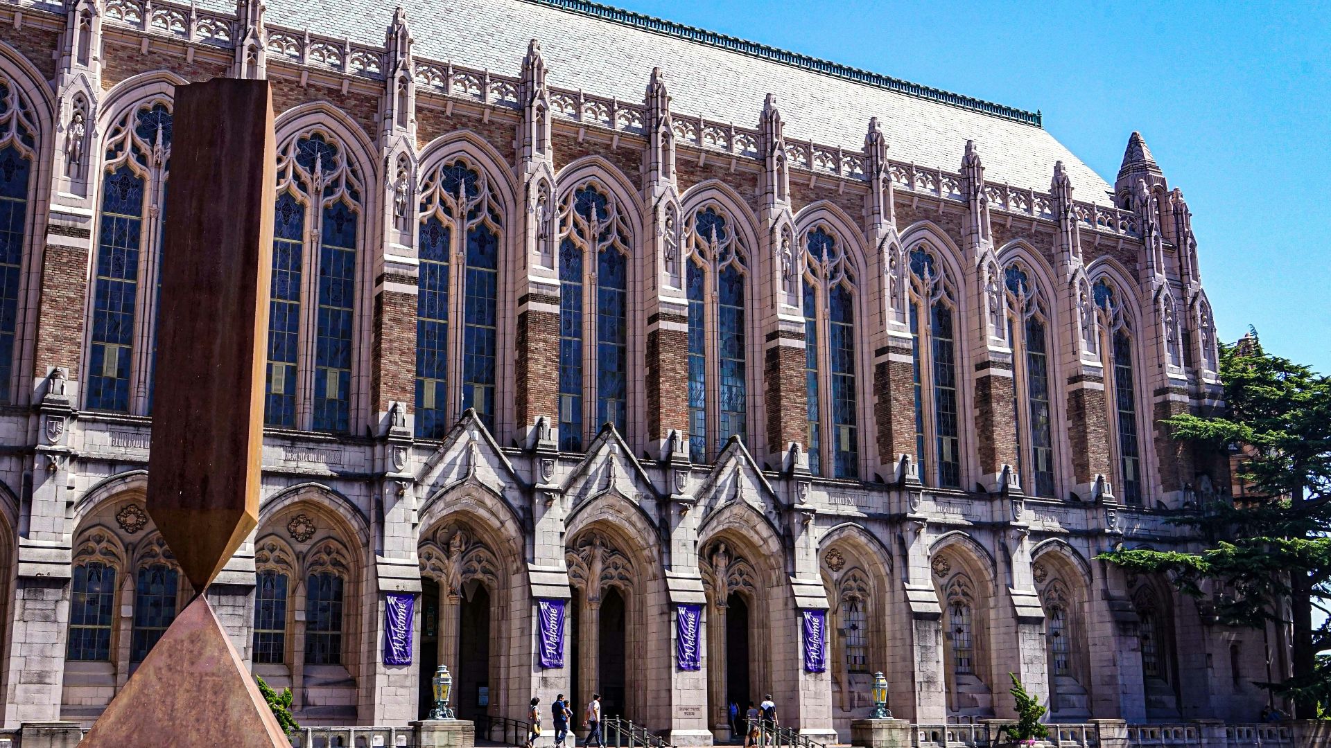 a large building with columns with Aqueduct of Segovia in the background