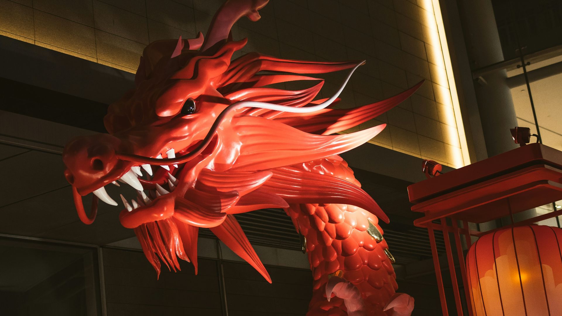 a large red dragon statue next to a lantern