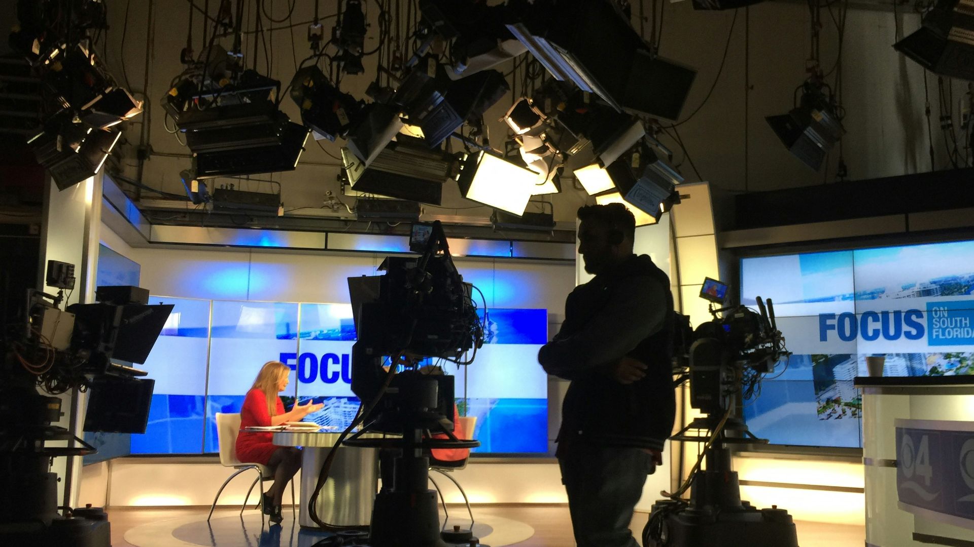 man in black suit standing on stage
