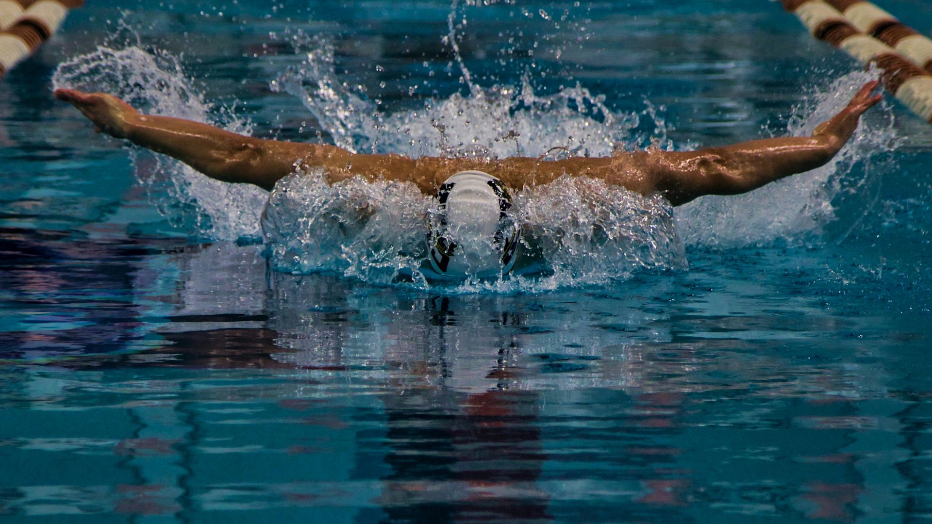 a man swimming in a pool with a swimming board