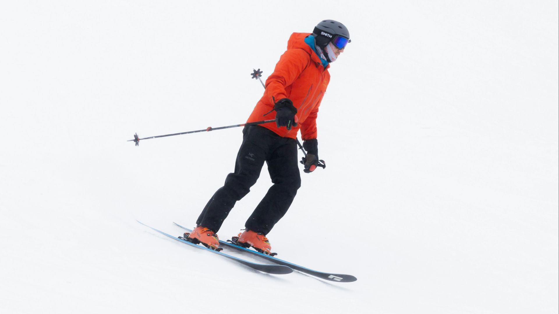 a man riding skis down a snow covered slope