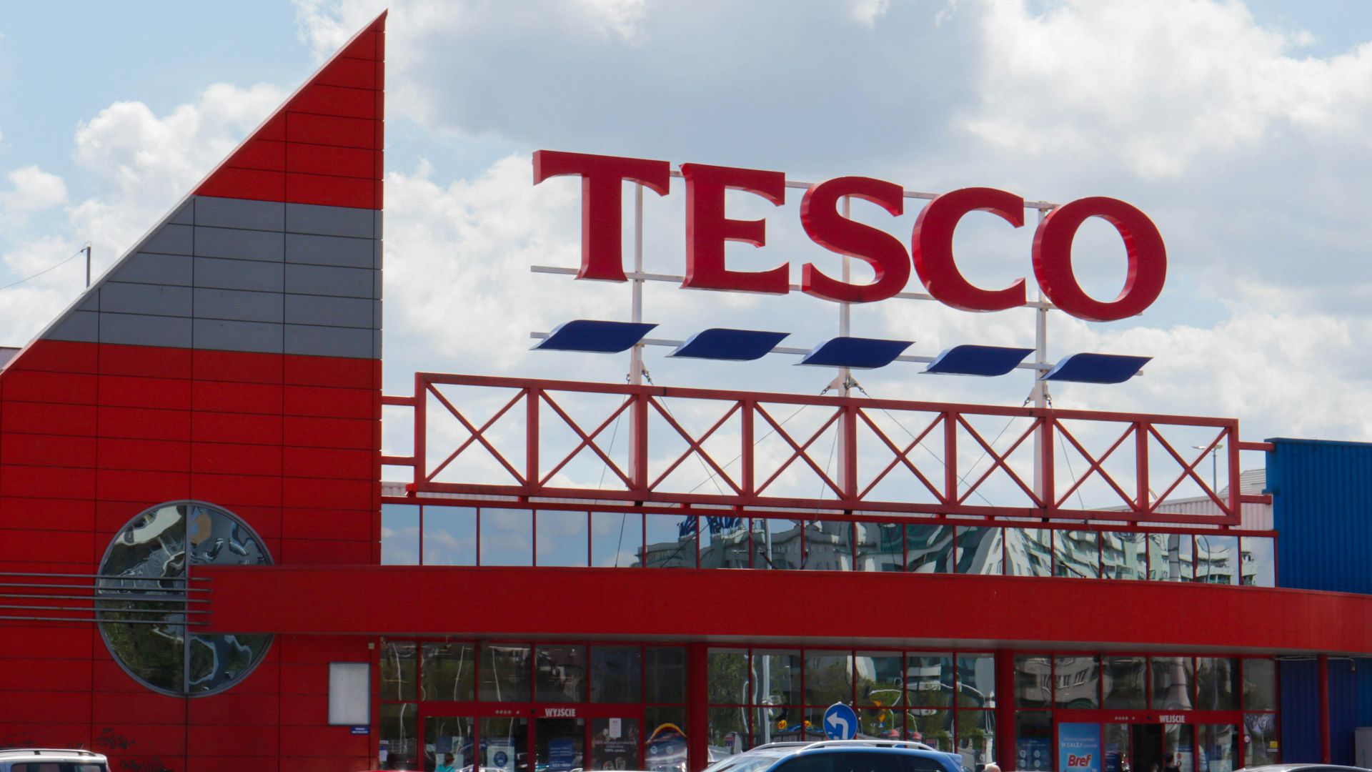 cars parked in front of UNKs building during daytime