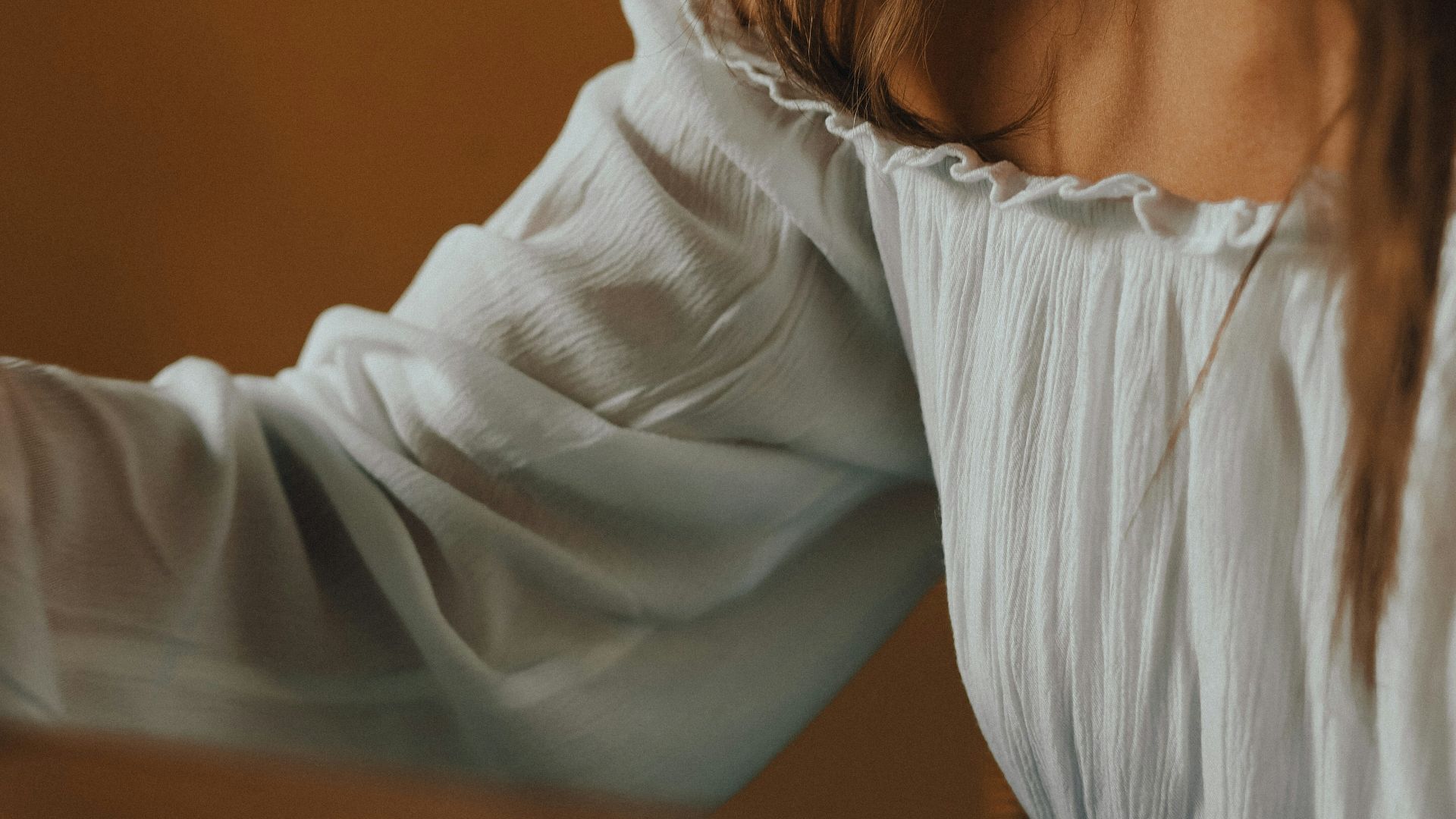 a woman in a white shirt is holding a cell phone