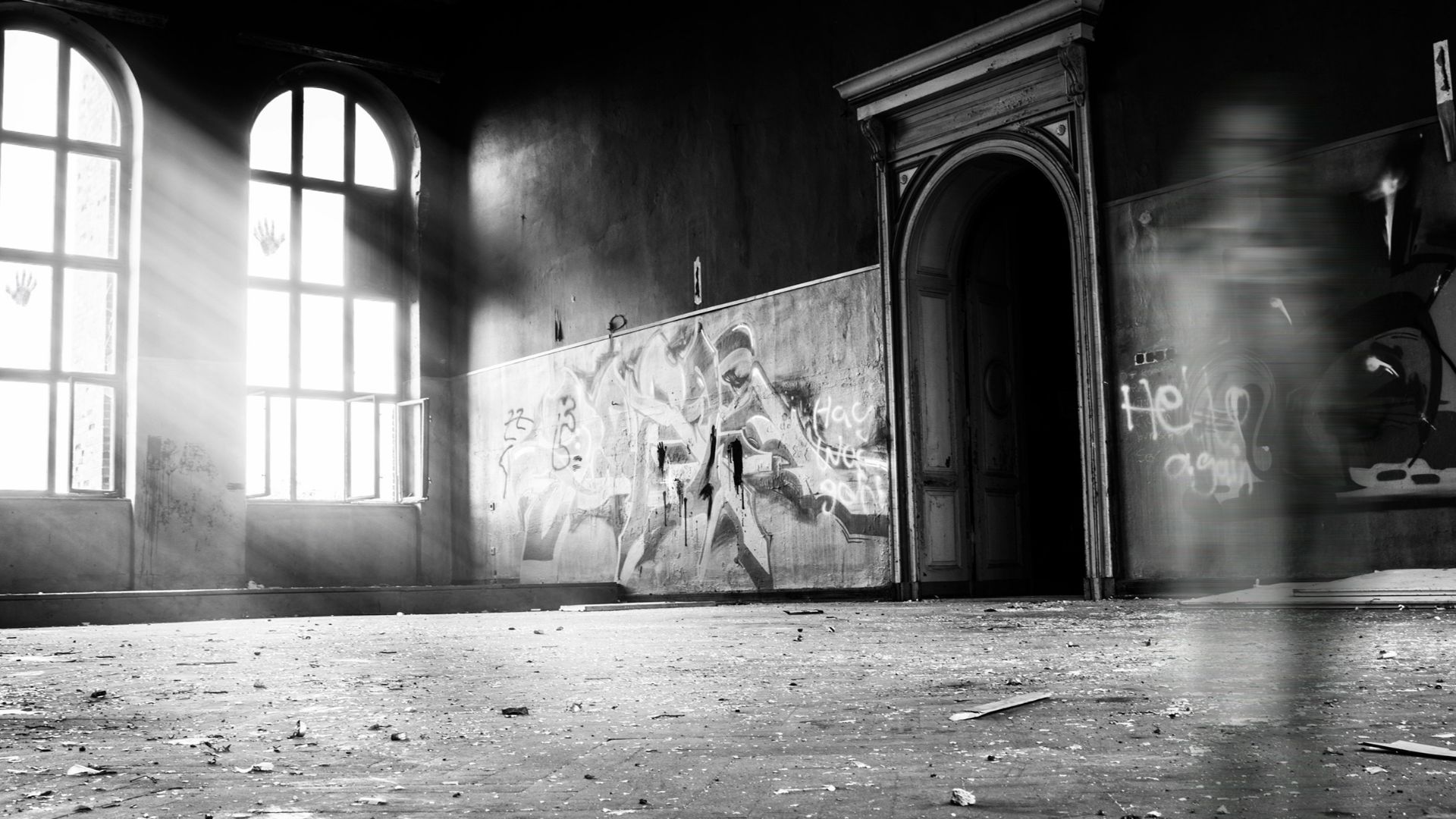 grayscale photo of person standing inside building