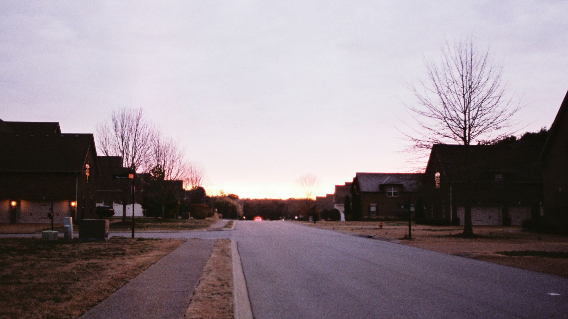 an empty street with houses in the background