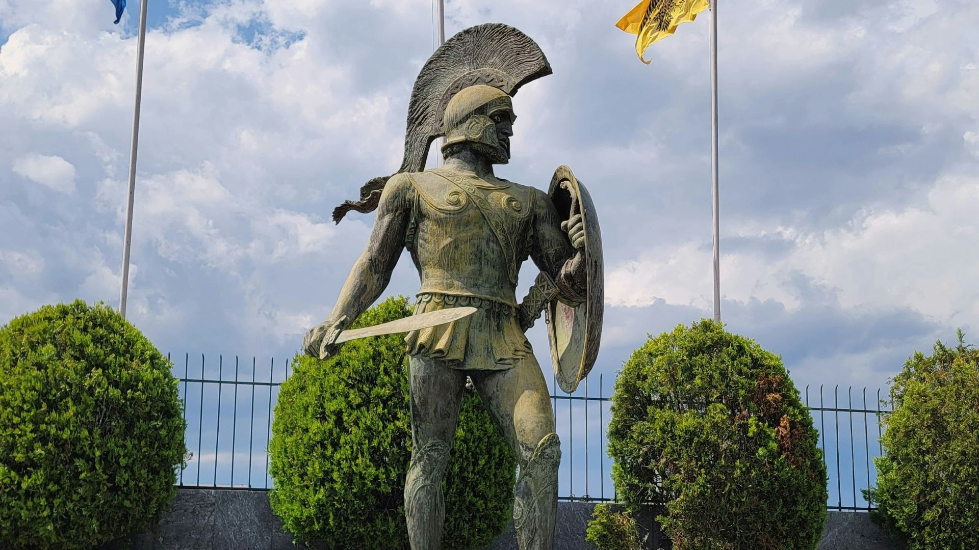 a statue of a man holding a shield and a shield
