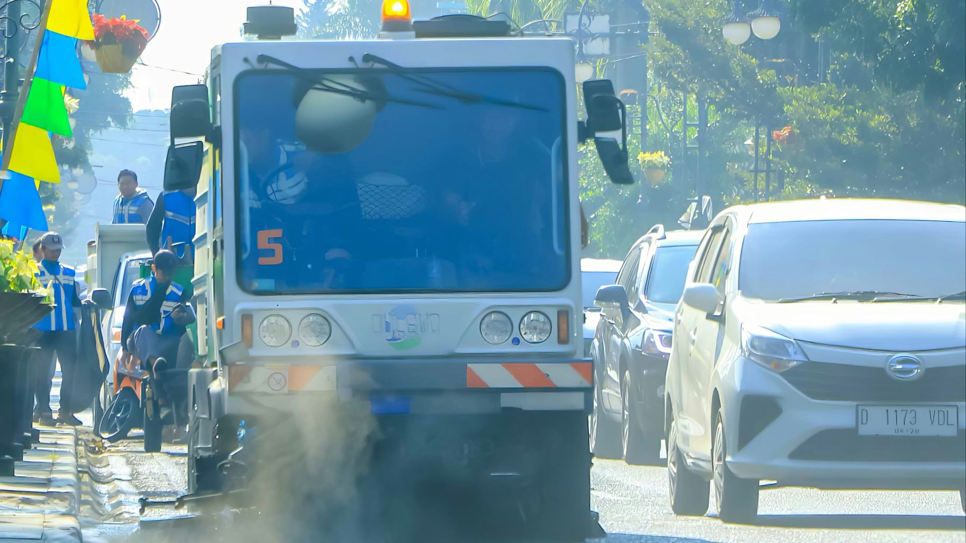 a truck driving down a street next to tall buildings