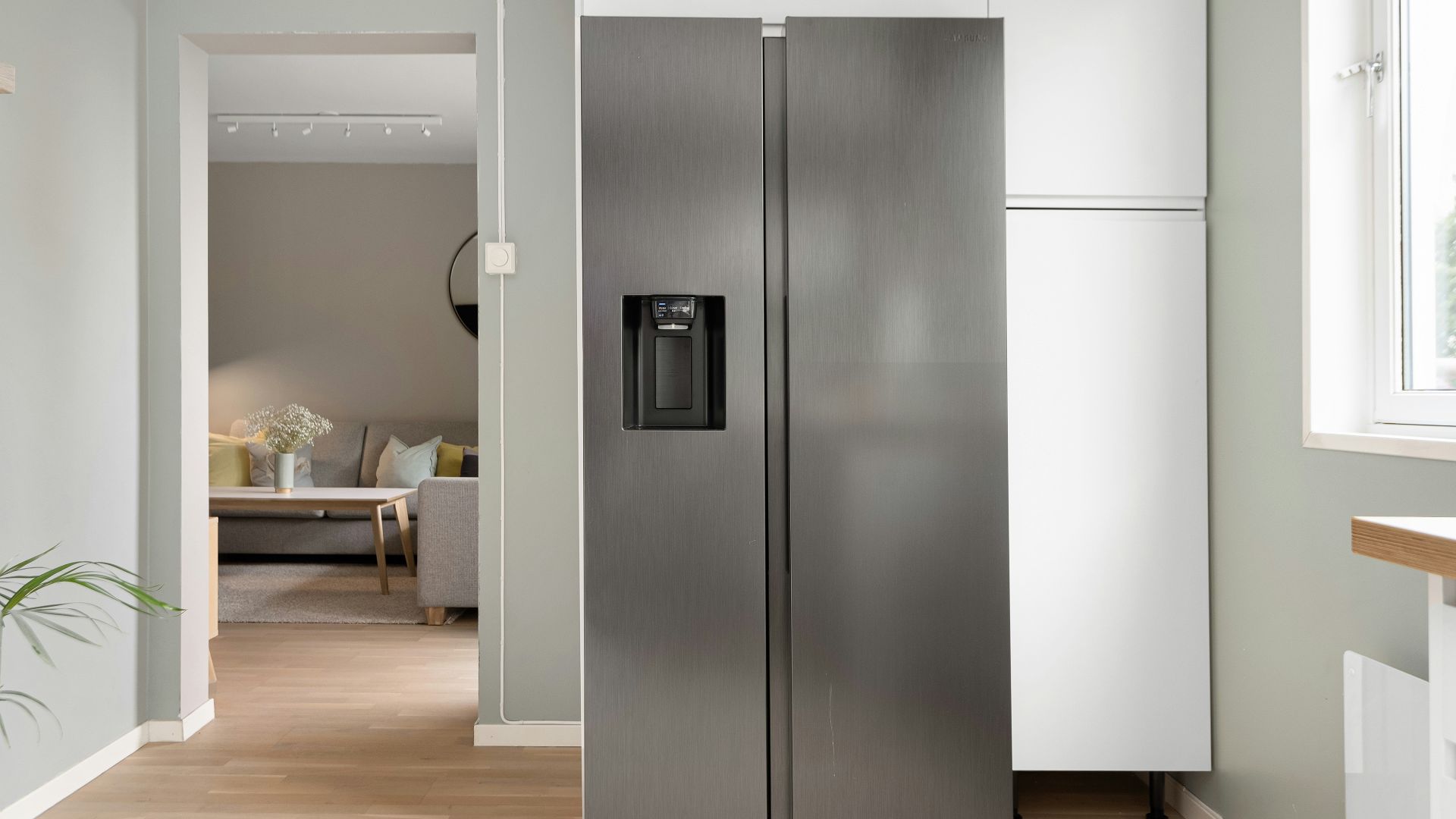 A refrigerator in a kitchen next to a window