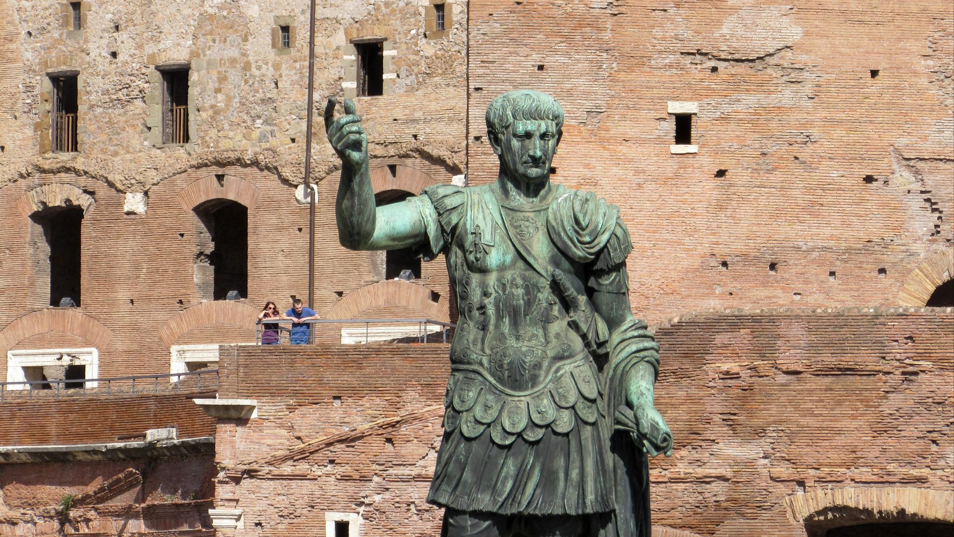 A statue of a roman soldier in front of a castle