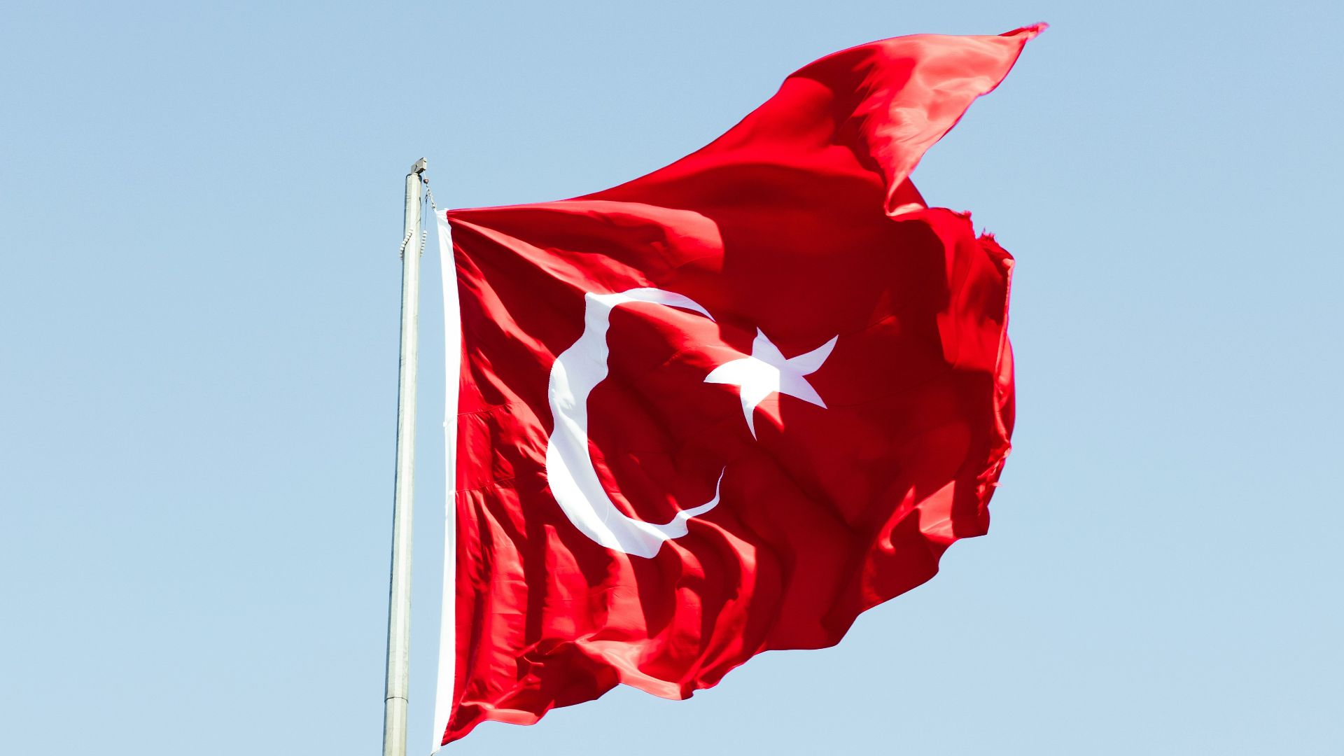 a flag flying in the wind on a clear day