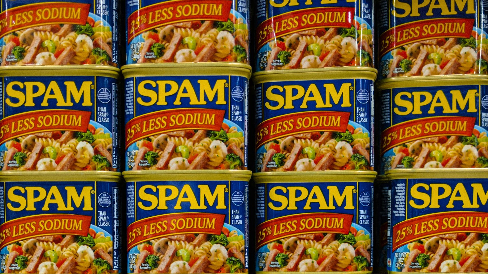 cans of spam are stacked on a shelf