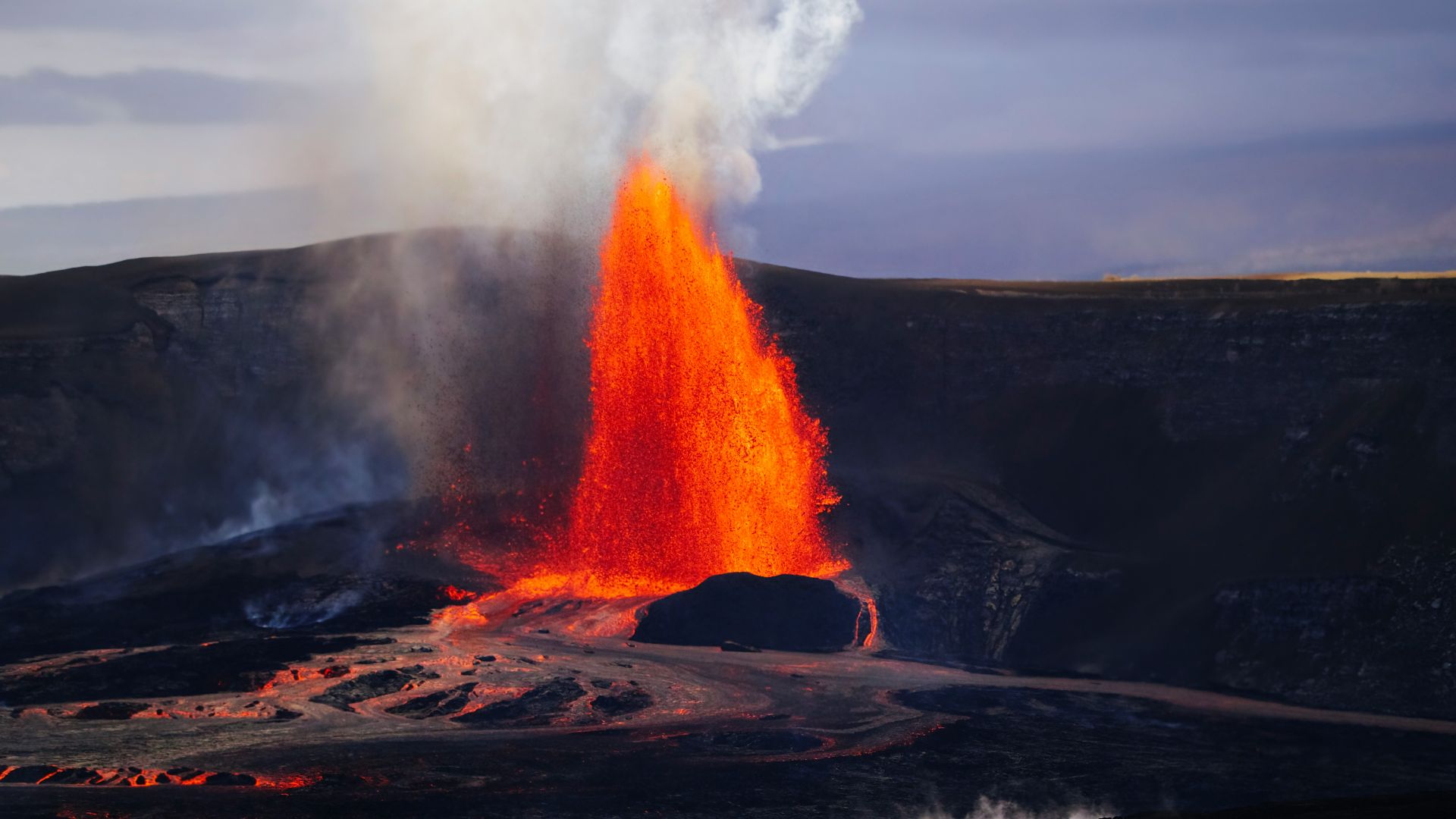 Volcanic eruption with bright orange lava spewing upwards.