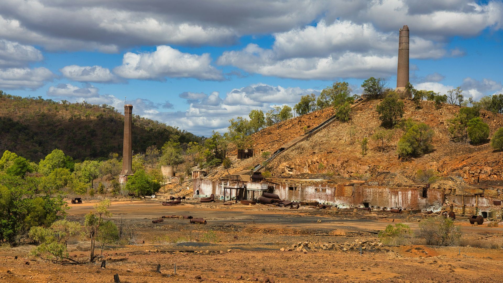 an old factory sits on top of a hill