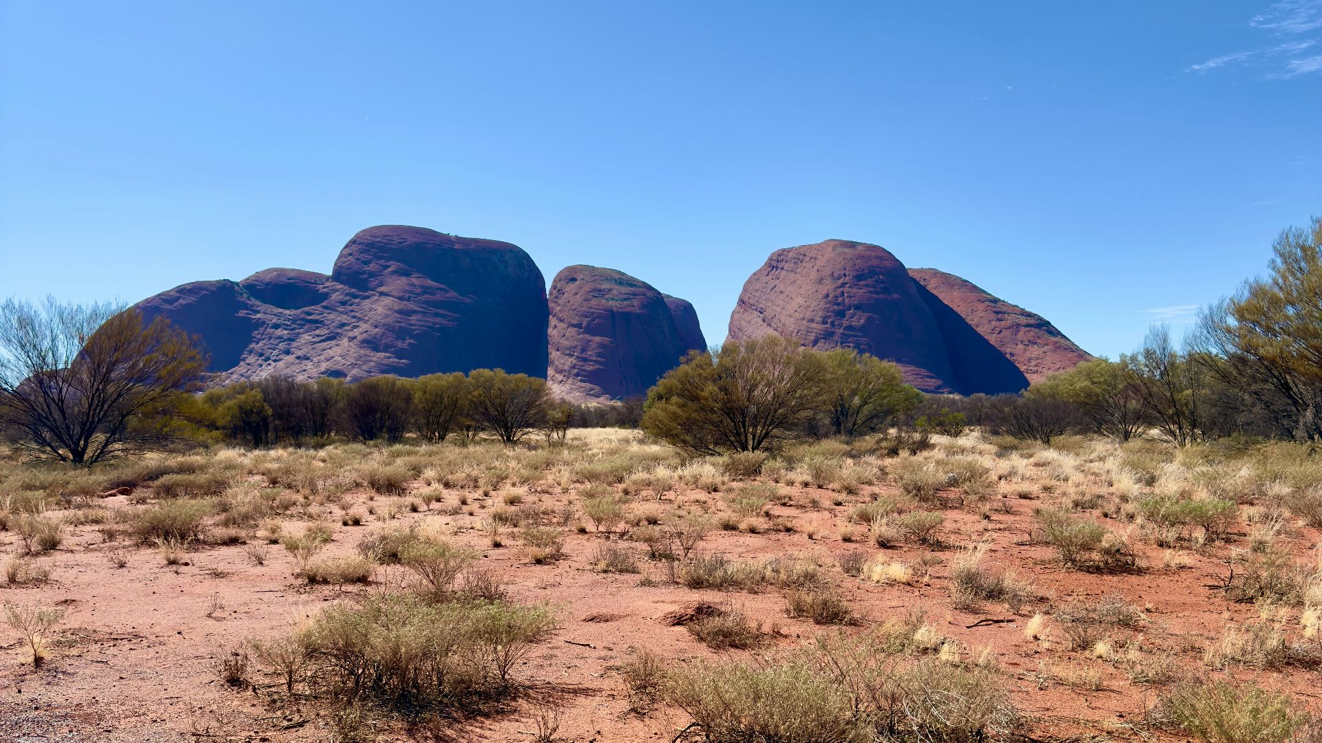 Vast desert landscape with large rock formations under clear sky