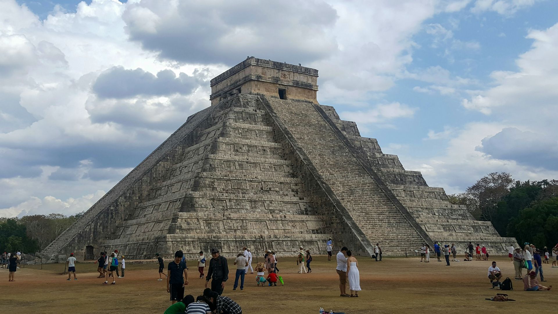 a group of people standing in front of a pyramid