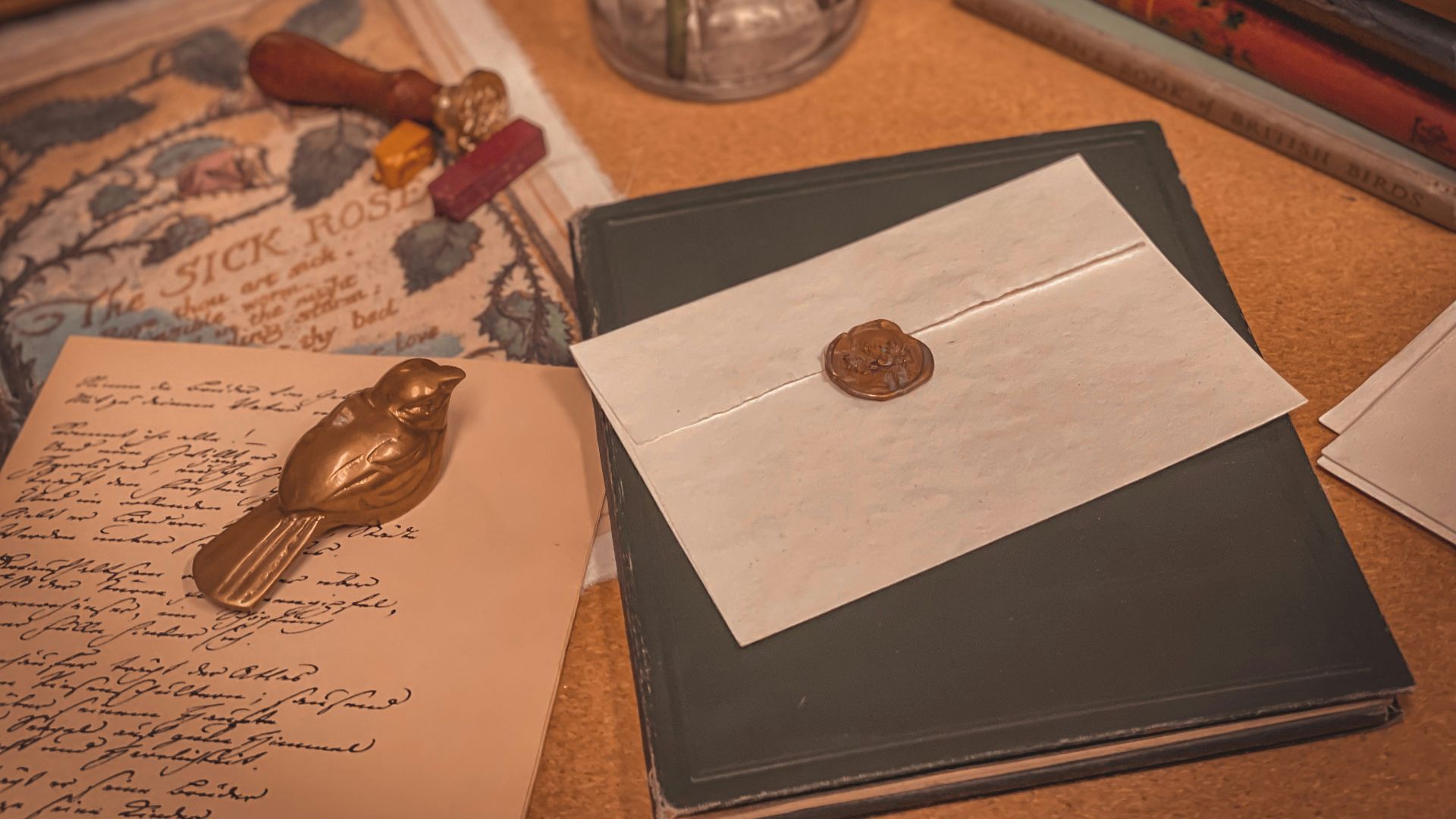a table topped with books and a wax stamp