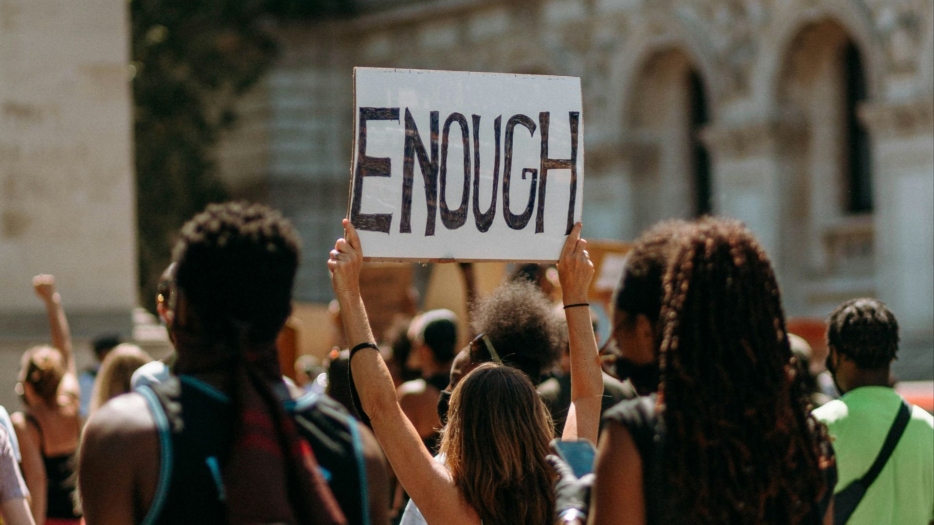 people holding a signage during daytime