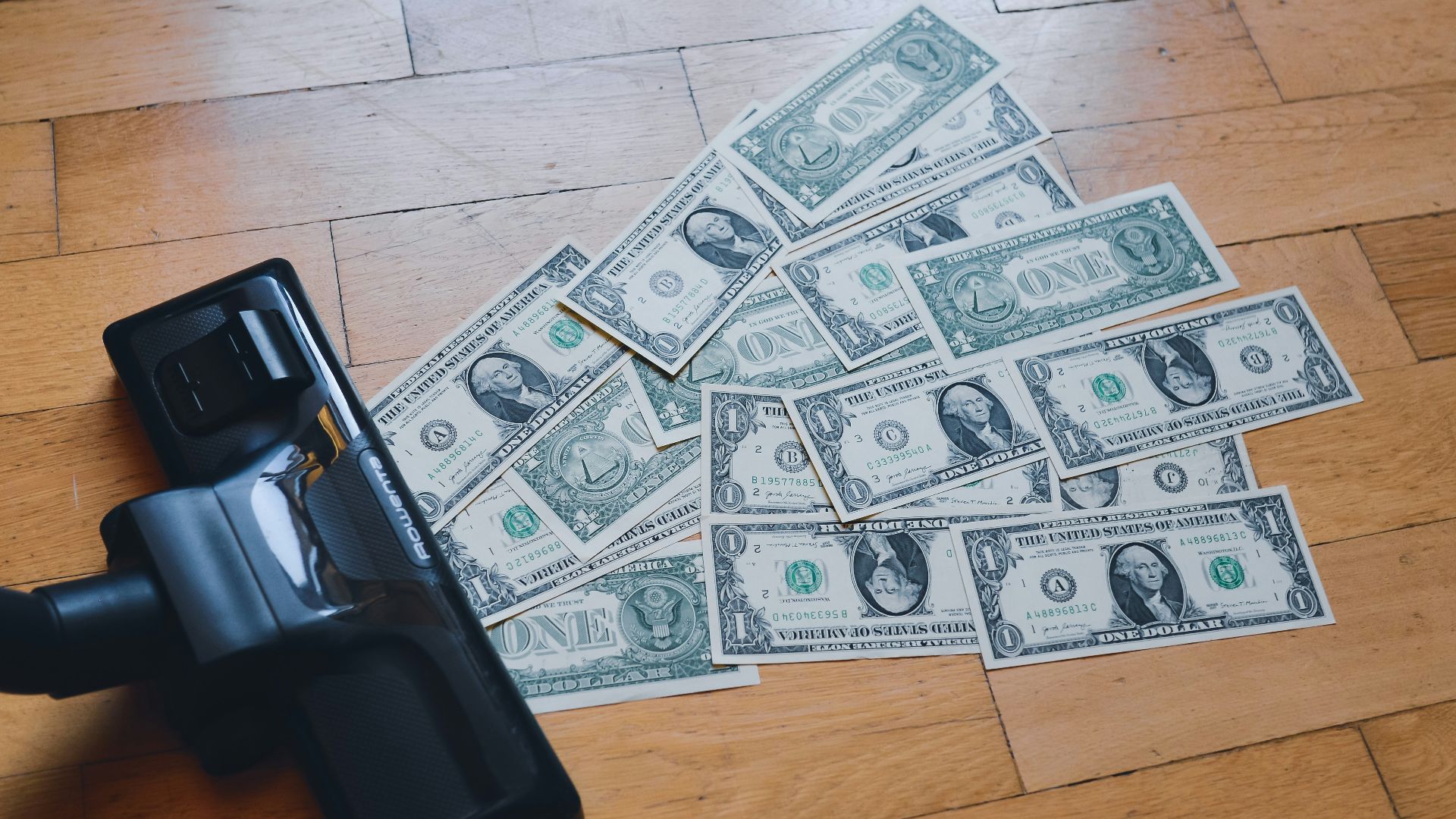 a pile of money sitting on top of a wooden floor