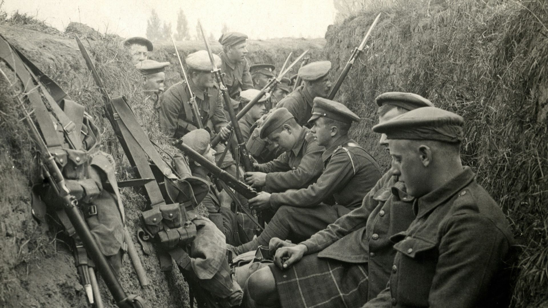a group of men sitting next to each other in a trench