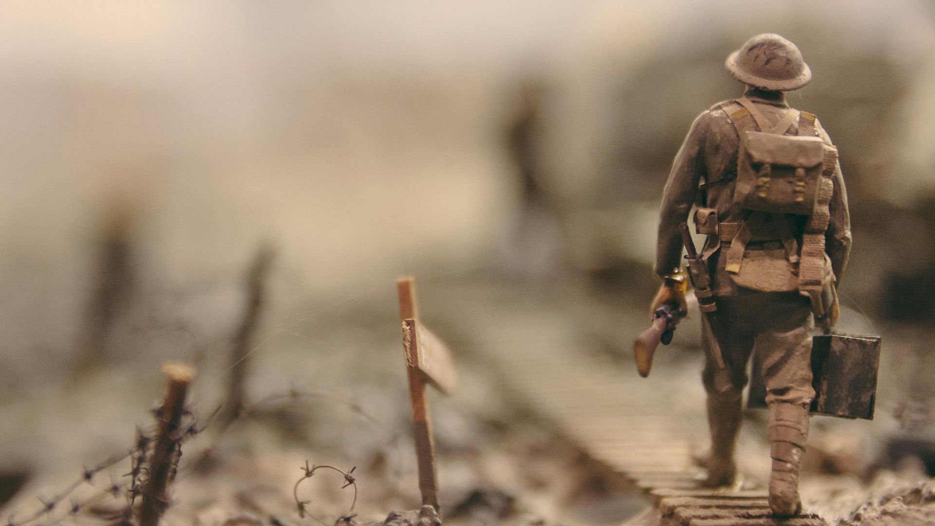 soldier walking on wooden pathway surrounded with barbwire selective focus photography