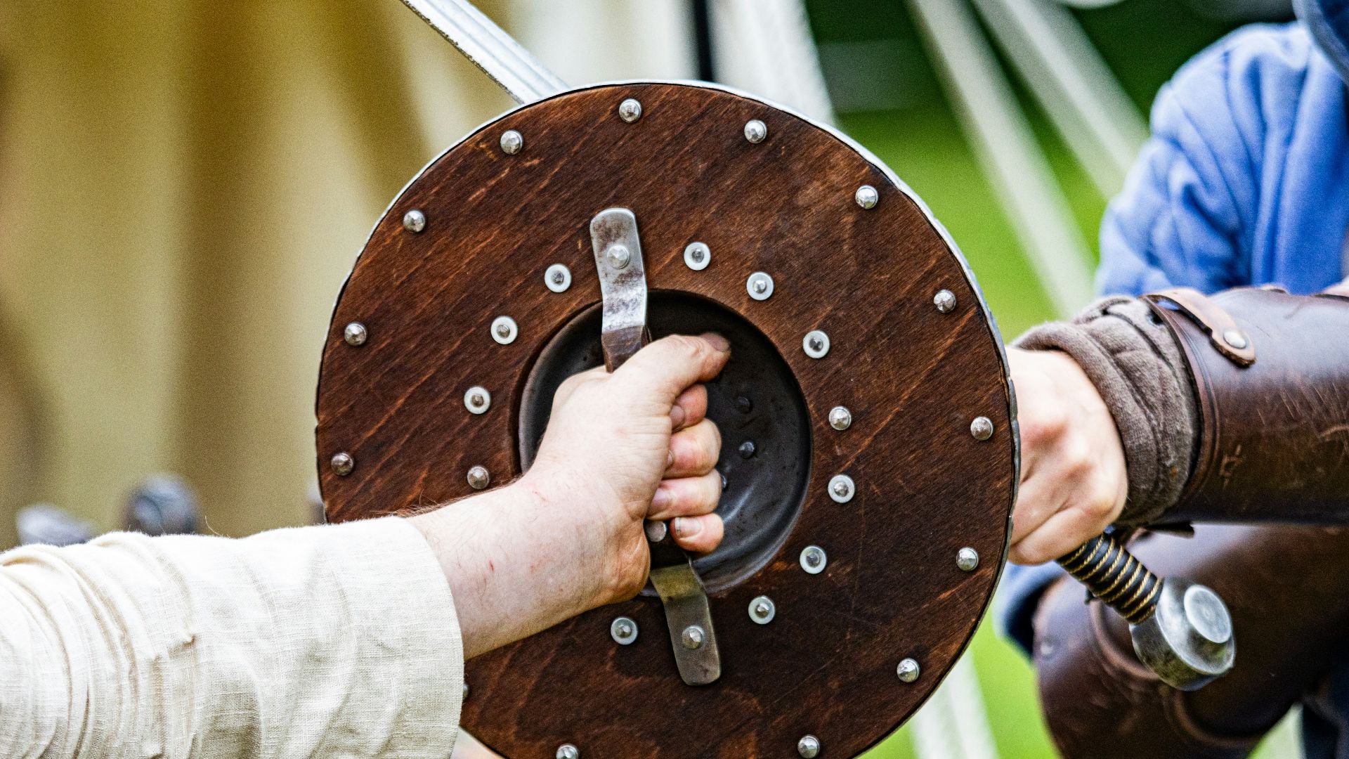a person holding a sword with another person's hand