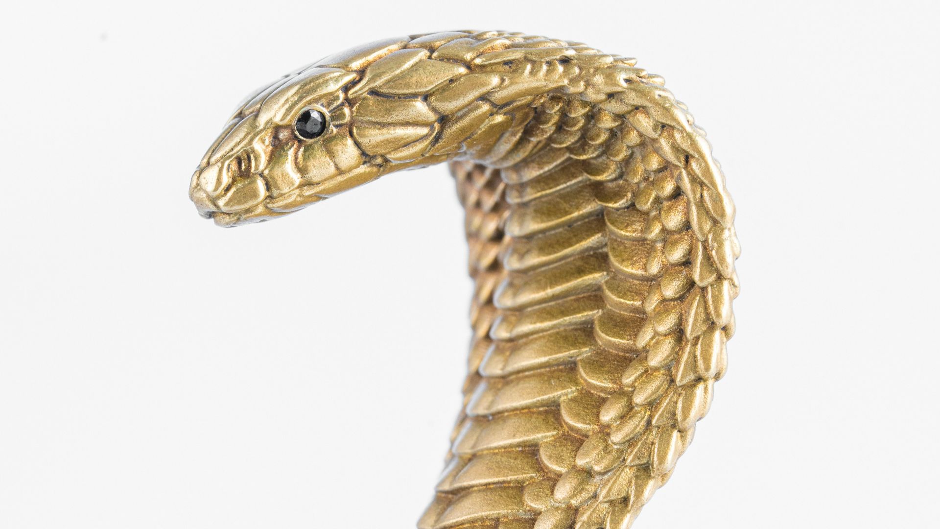 a gold snake statue sitting on top of a table