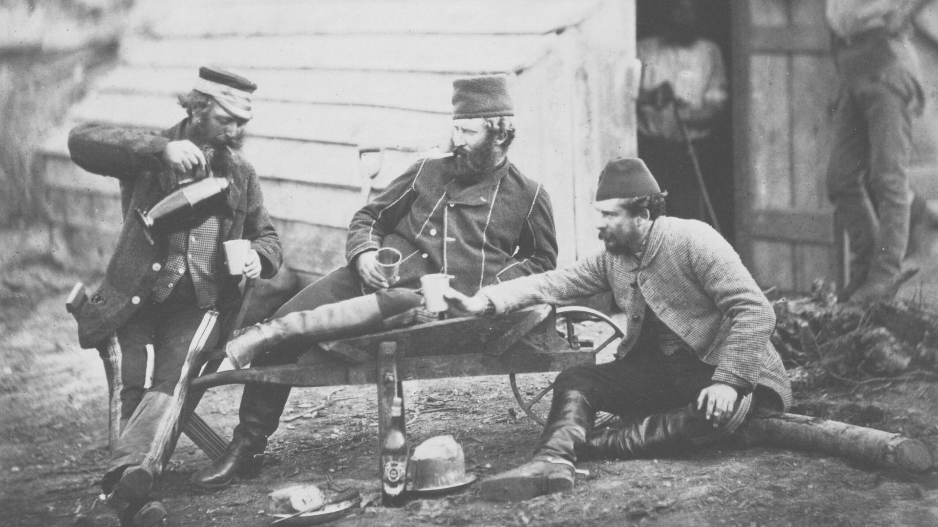 a group of men sitting around a wooden structure