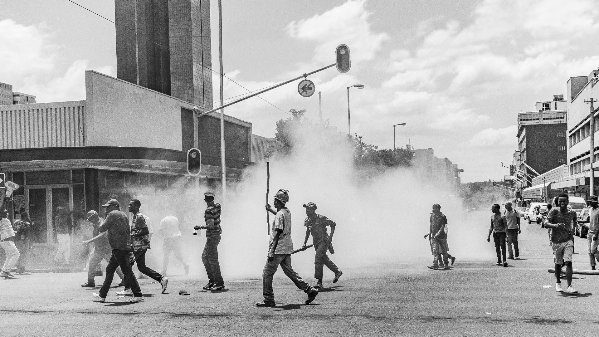 grayscale photo of people on street near buildings during daytime