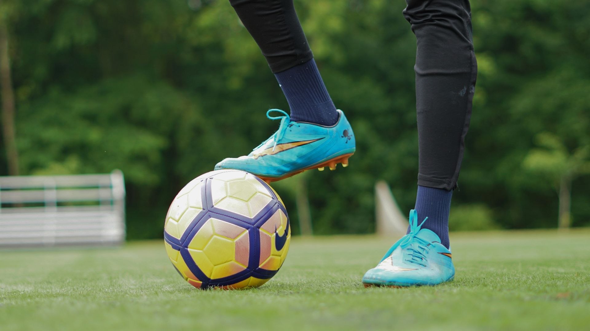 person in blue nike soccer shoes and black pants