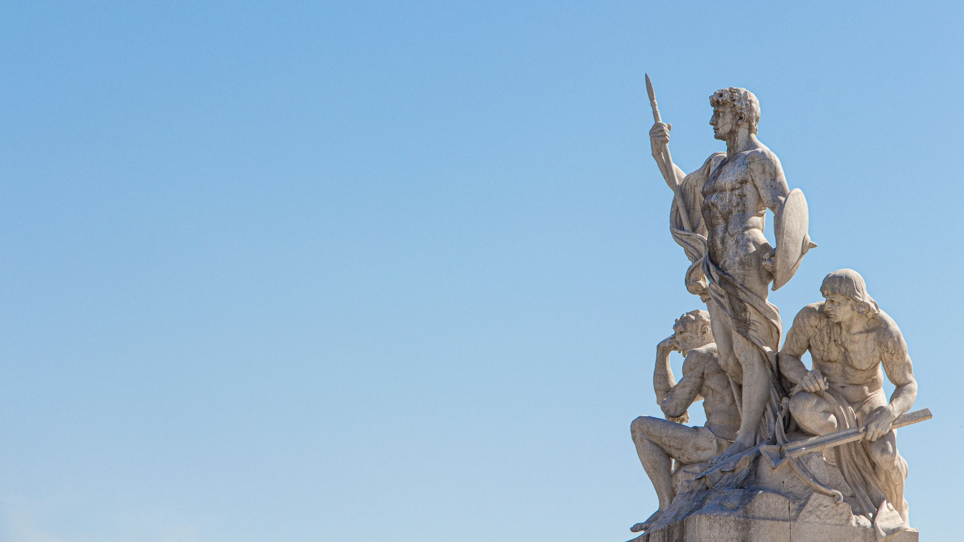 three men holding sword and shield statue