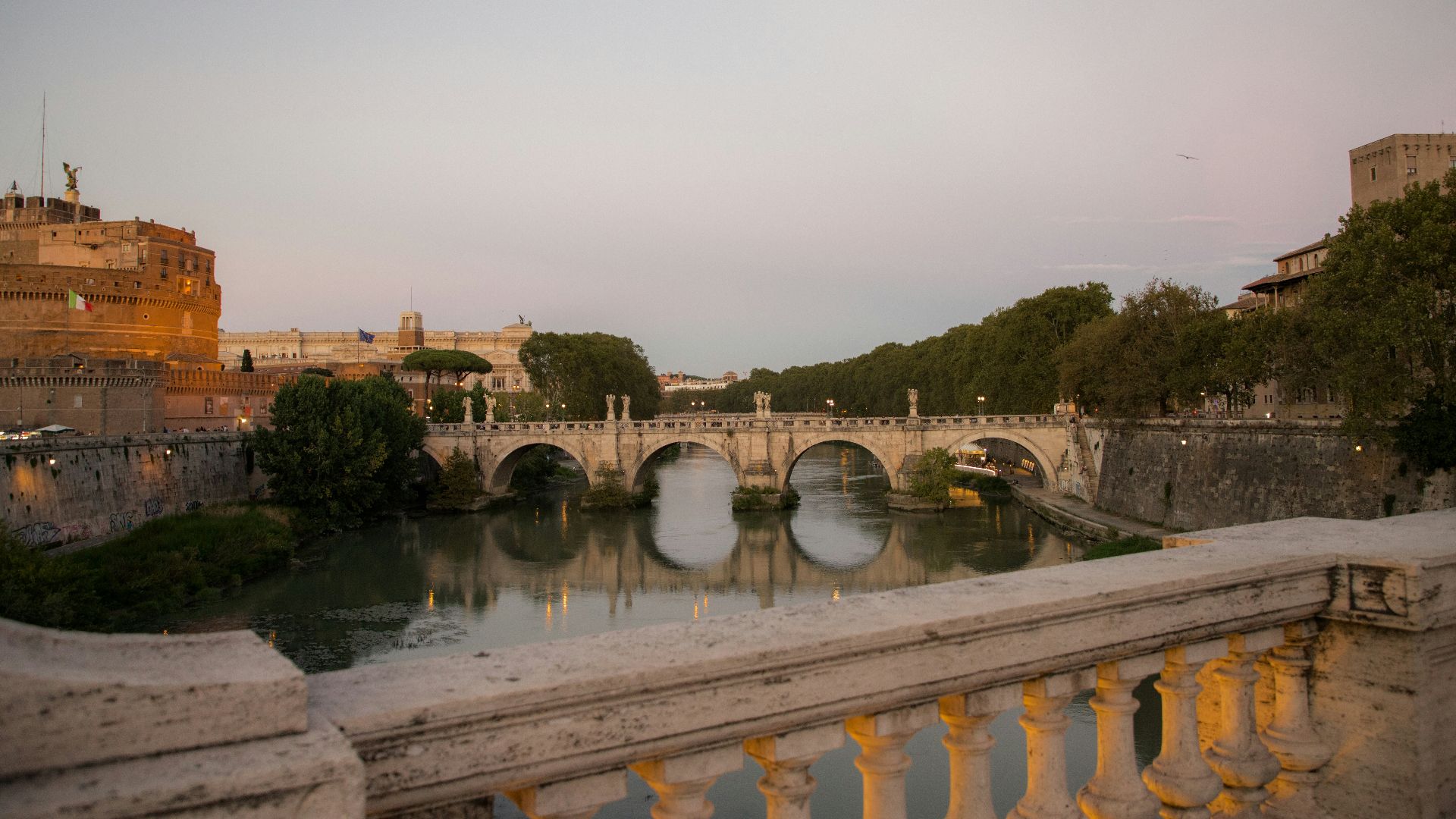 a bridge over a river next to a tall building