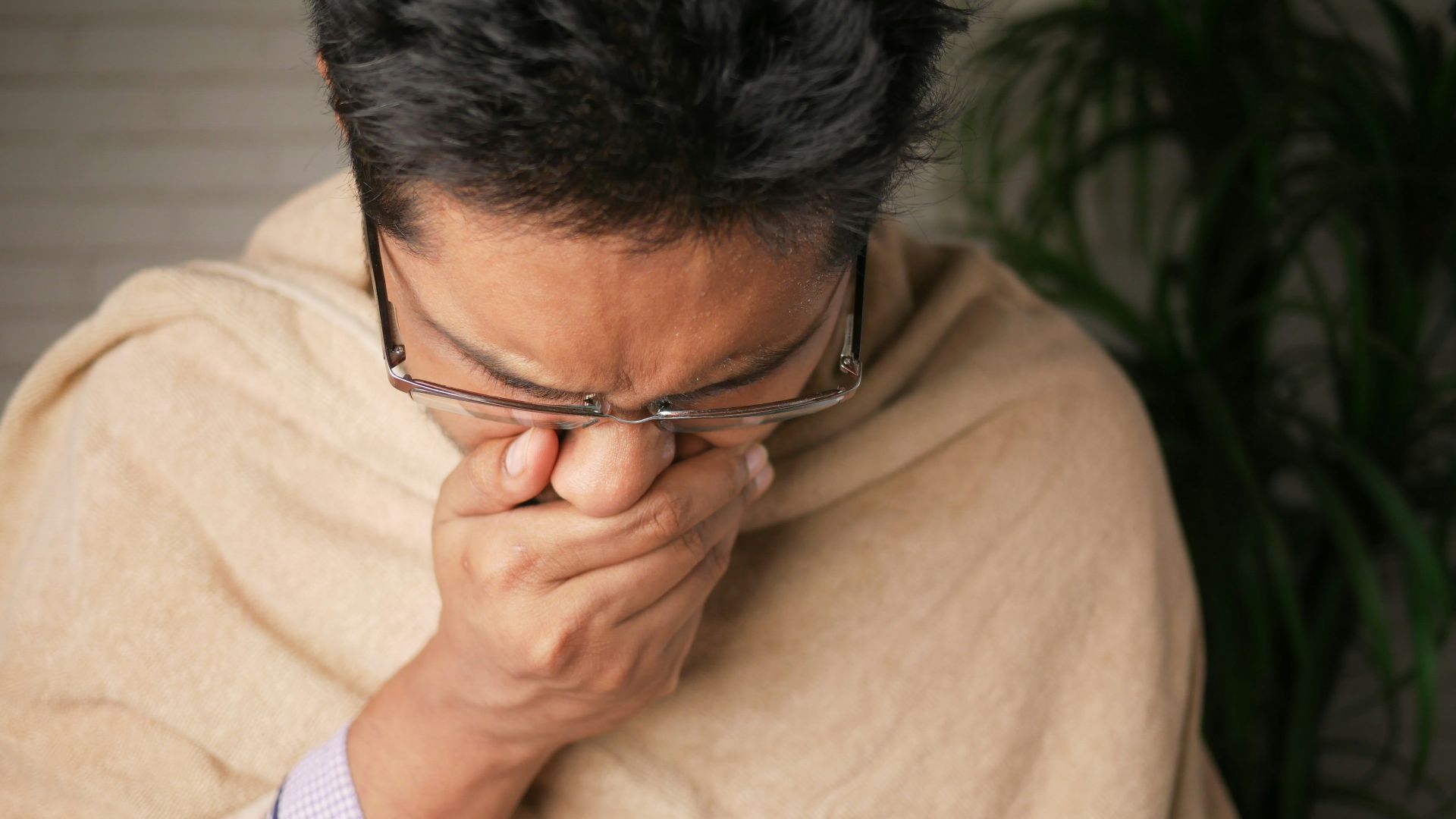 man in brown sweater wearing black framed eyeglasses