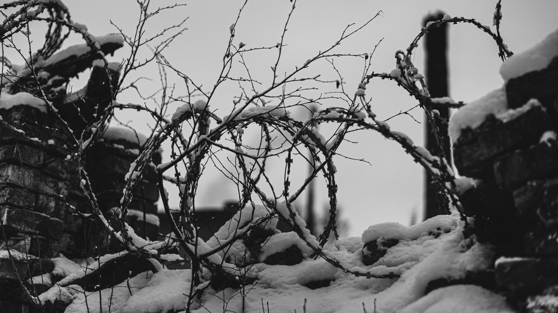 a black and white photo of a fence covered in snow