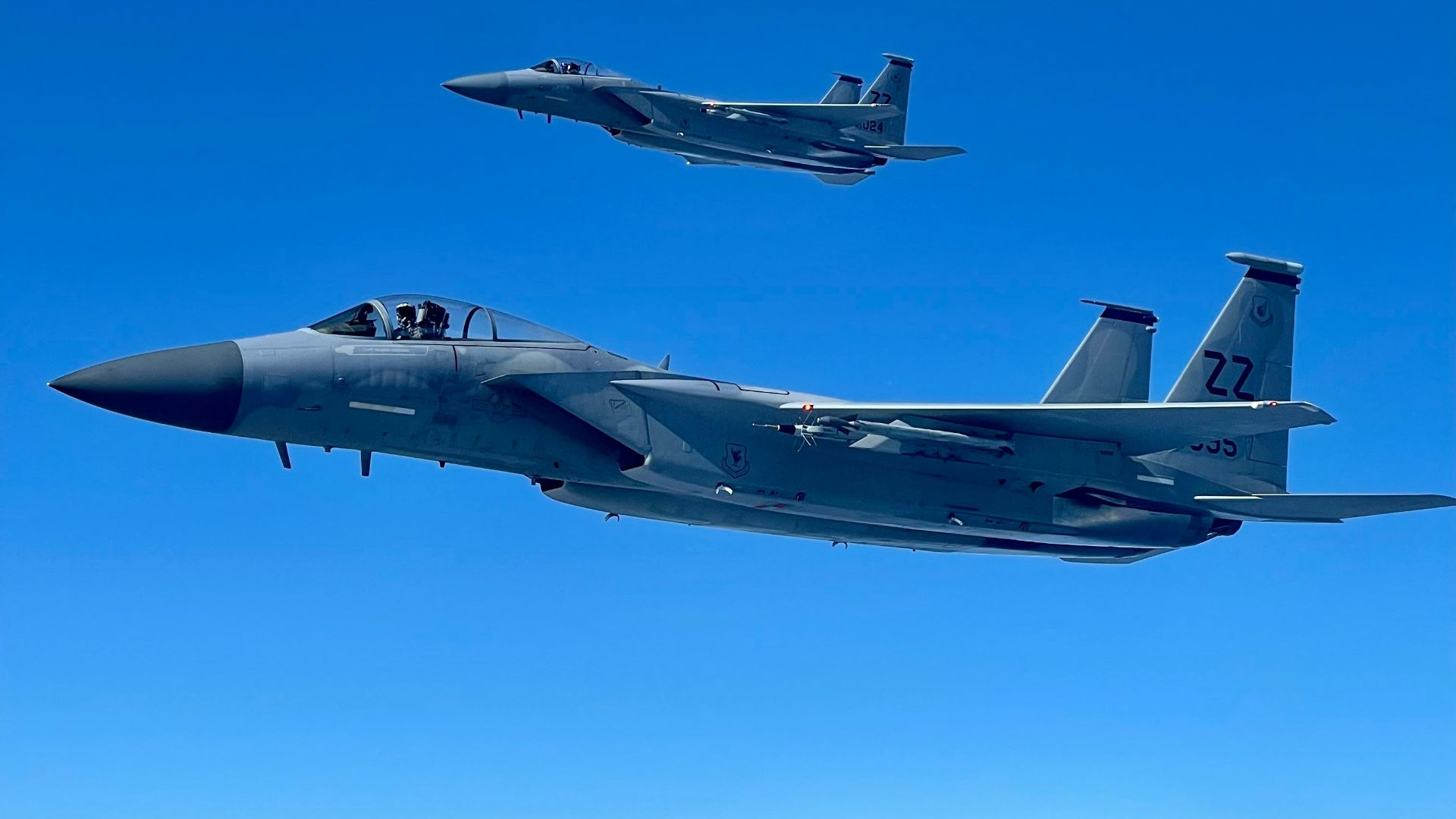 two fighter jets flying next to each other in the sky