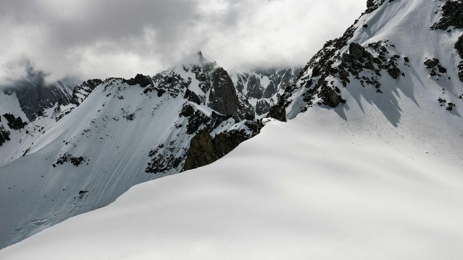 man climbing snow-covered mountain