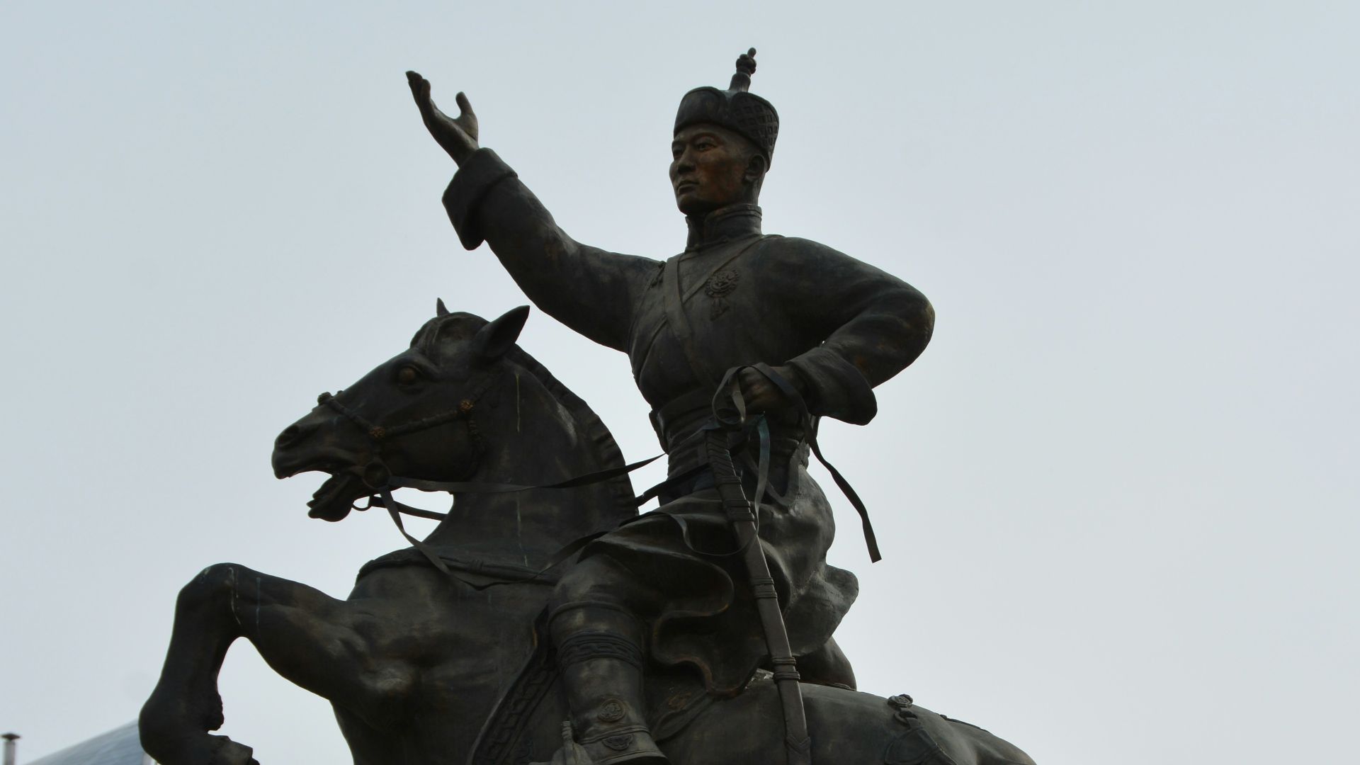 a statue of a man riding a horse next to a tall building
