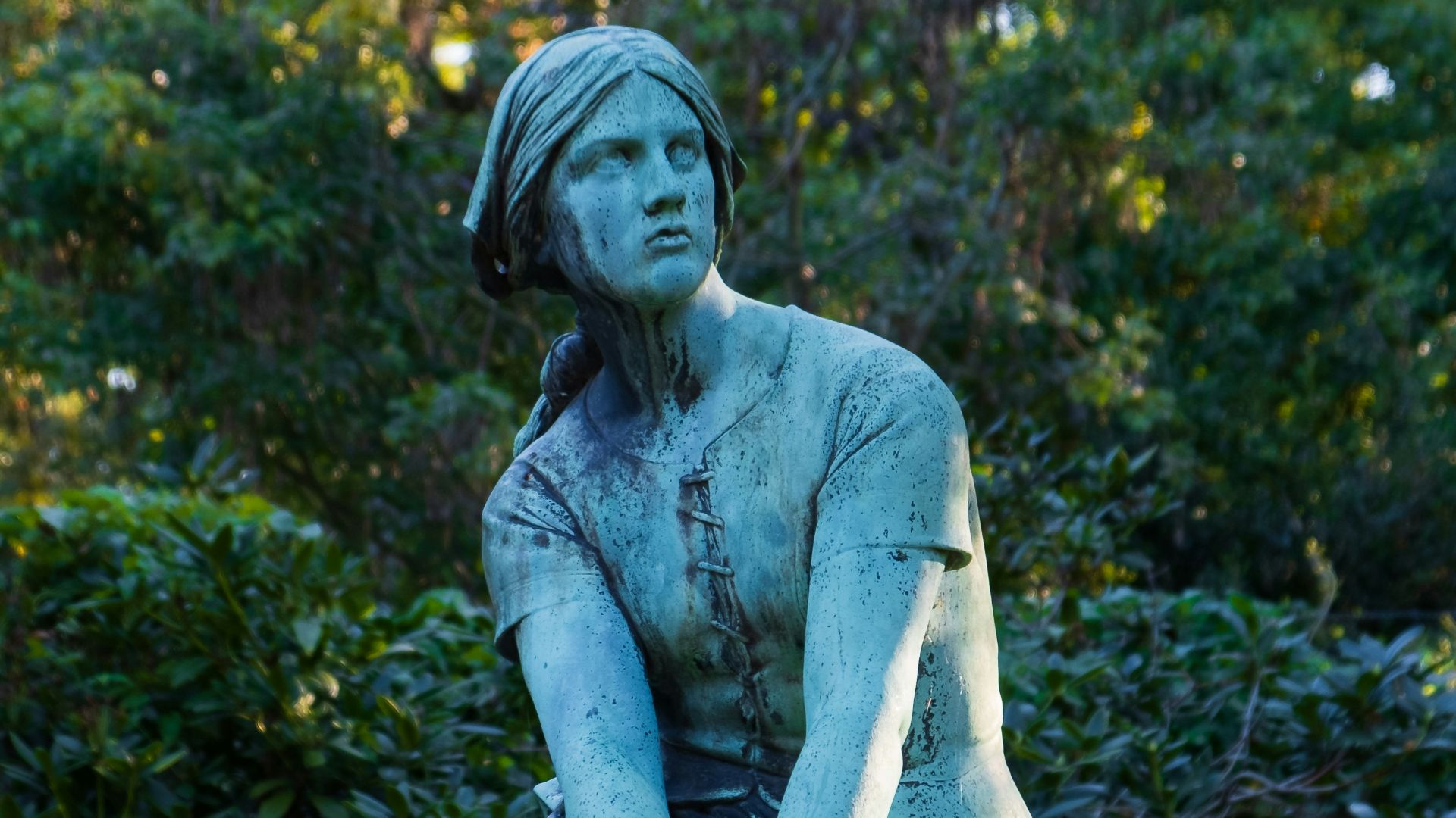 A statue of a woman sitting on top of a cement block