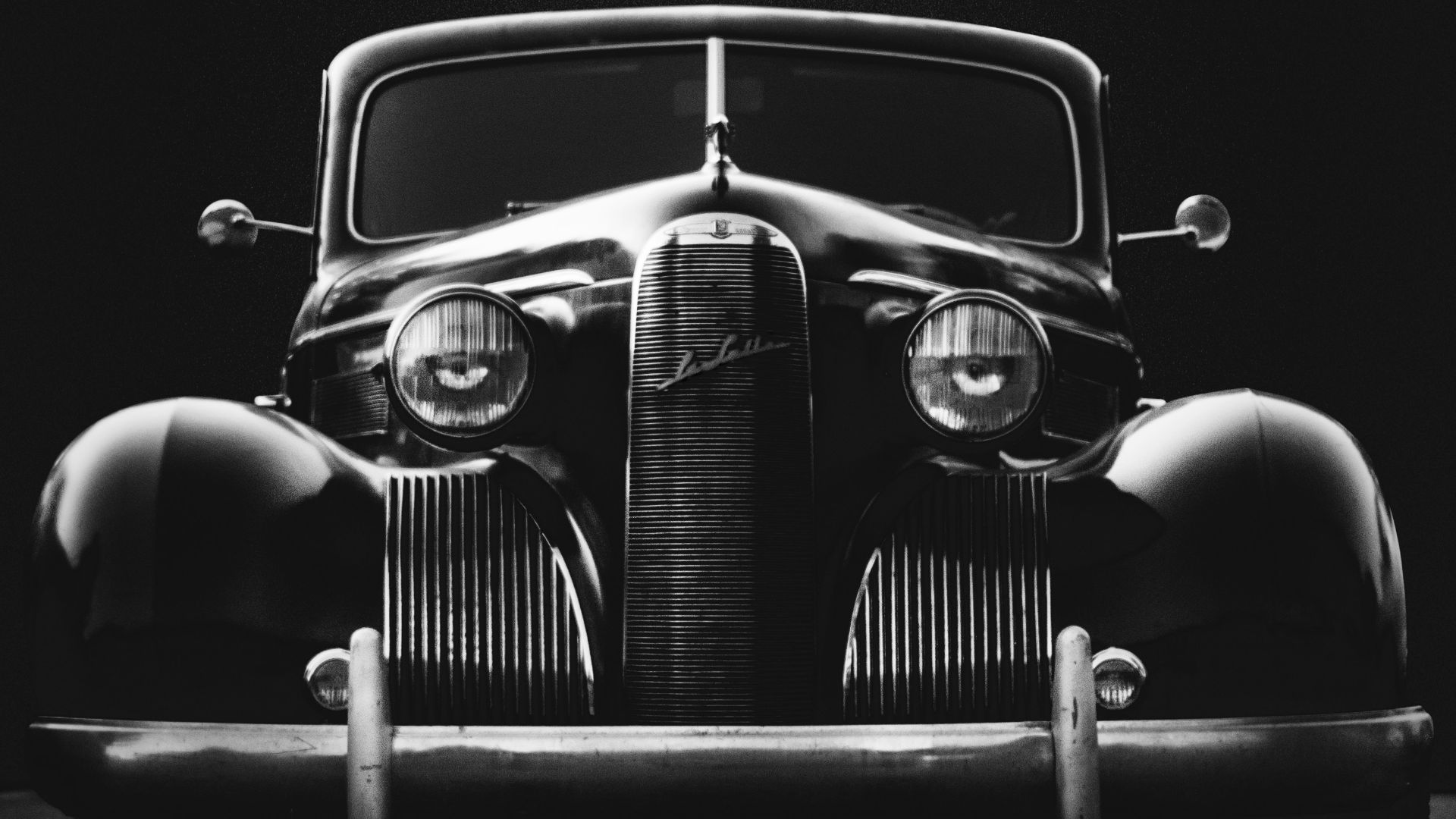 greyscale photo of classic vehicle on ground