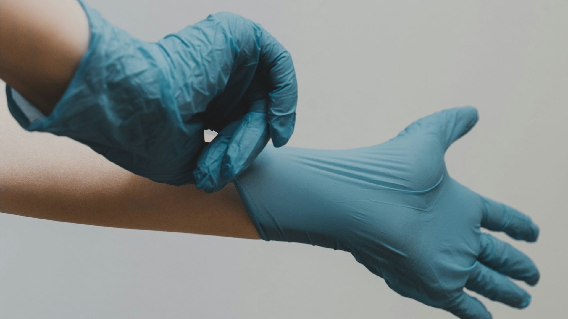 person in blue gloves and blue denim jeans