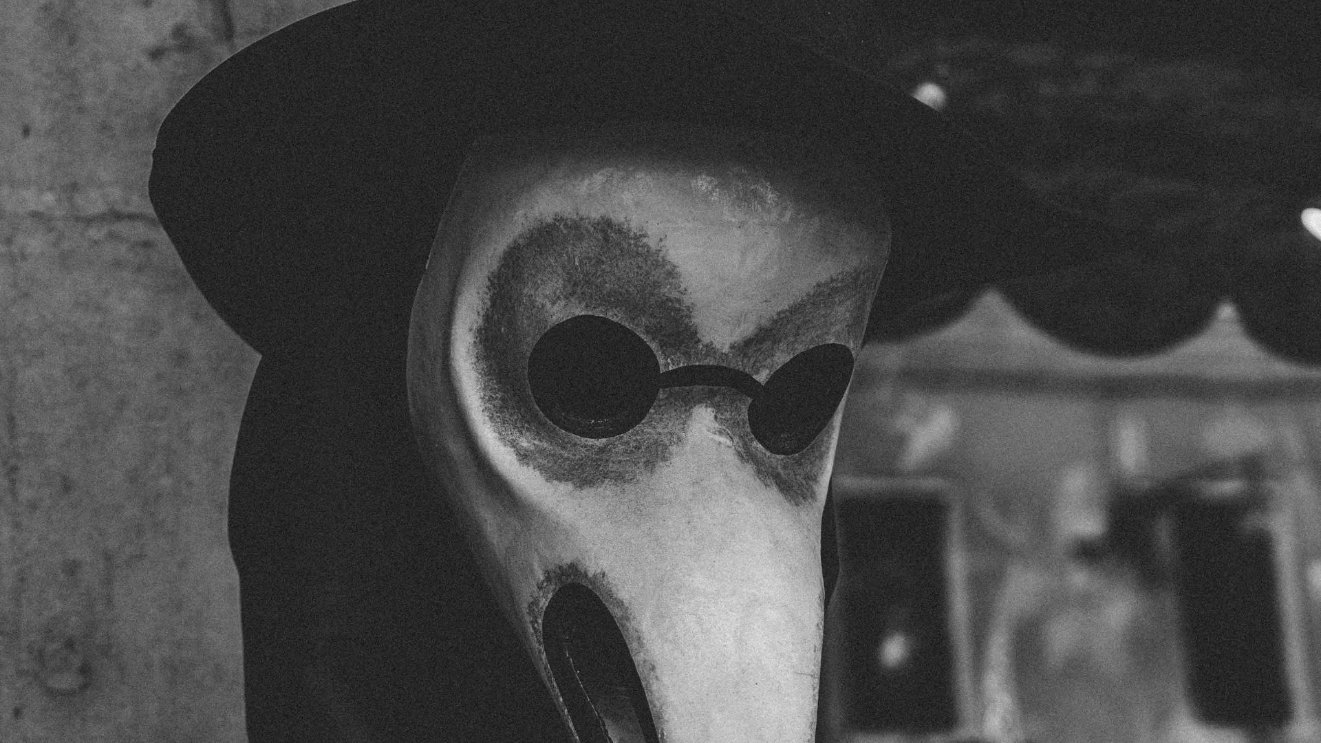 grayscale photo of man wearing gray mask