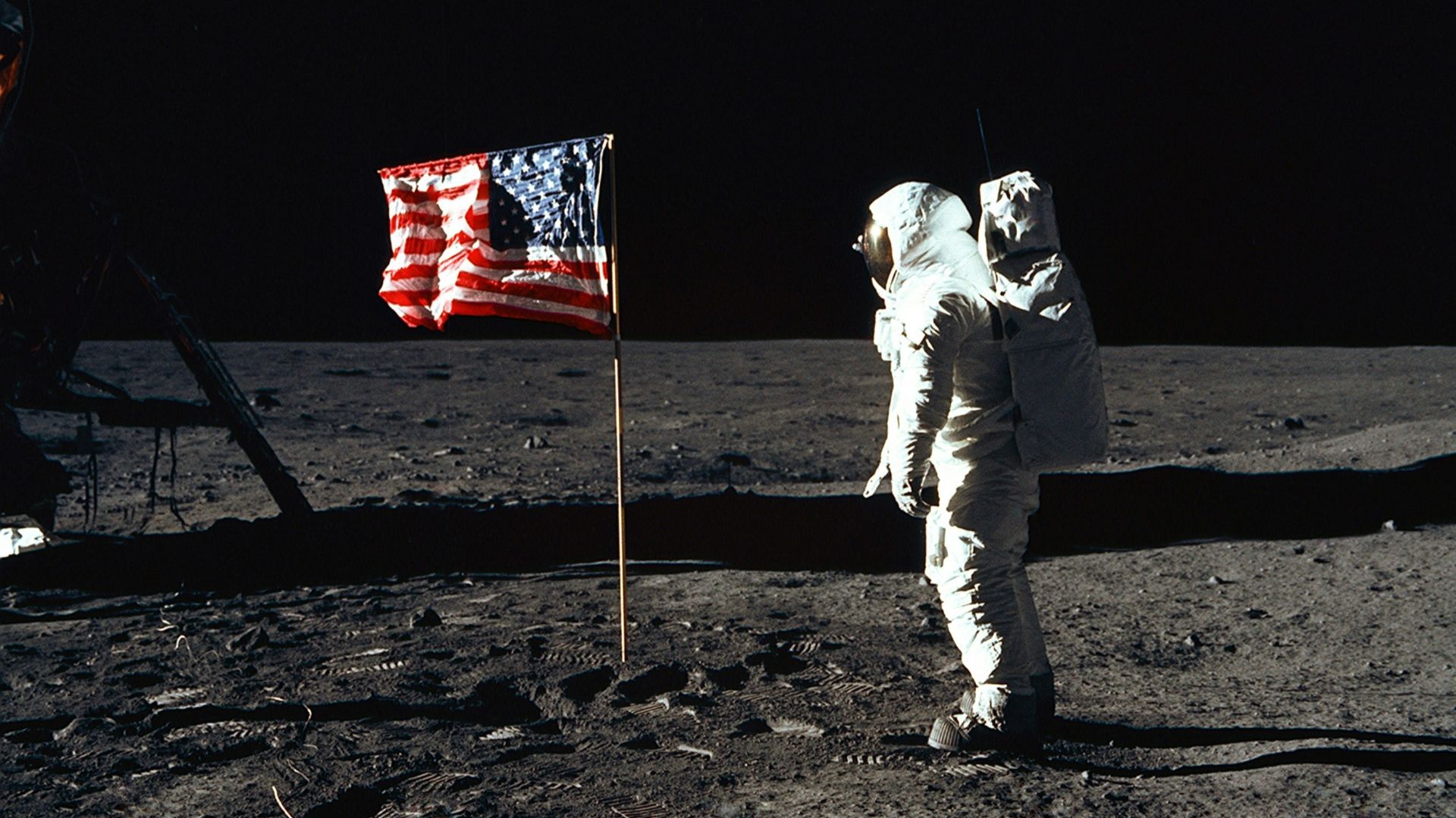Buzz Aldrin on the moon in front of the US flag