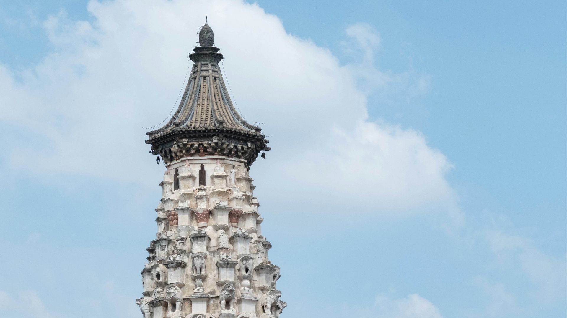 Ornate pagoda tower behind a red wall