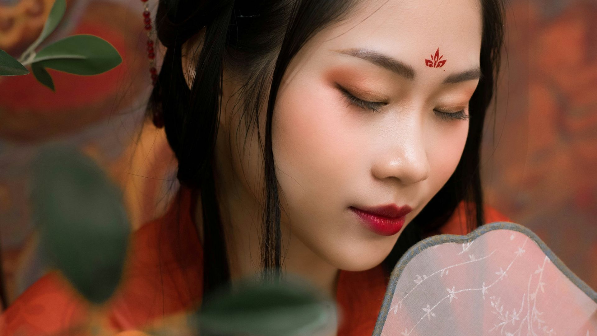 a woman in a red dress holding a fan