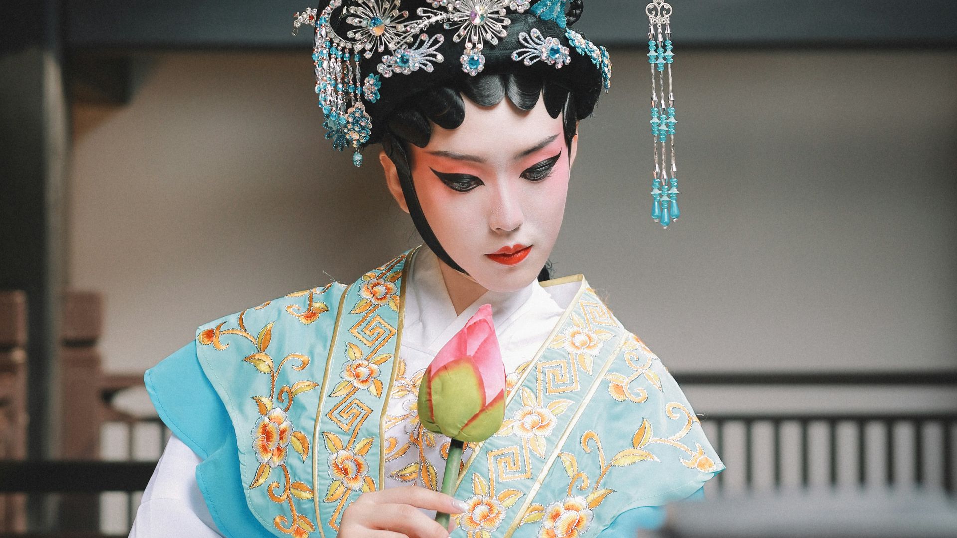 a woman in a geisha costume holding a flower