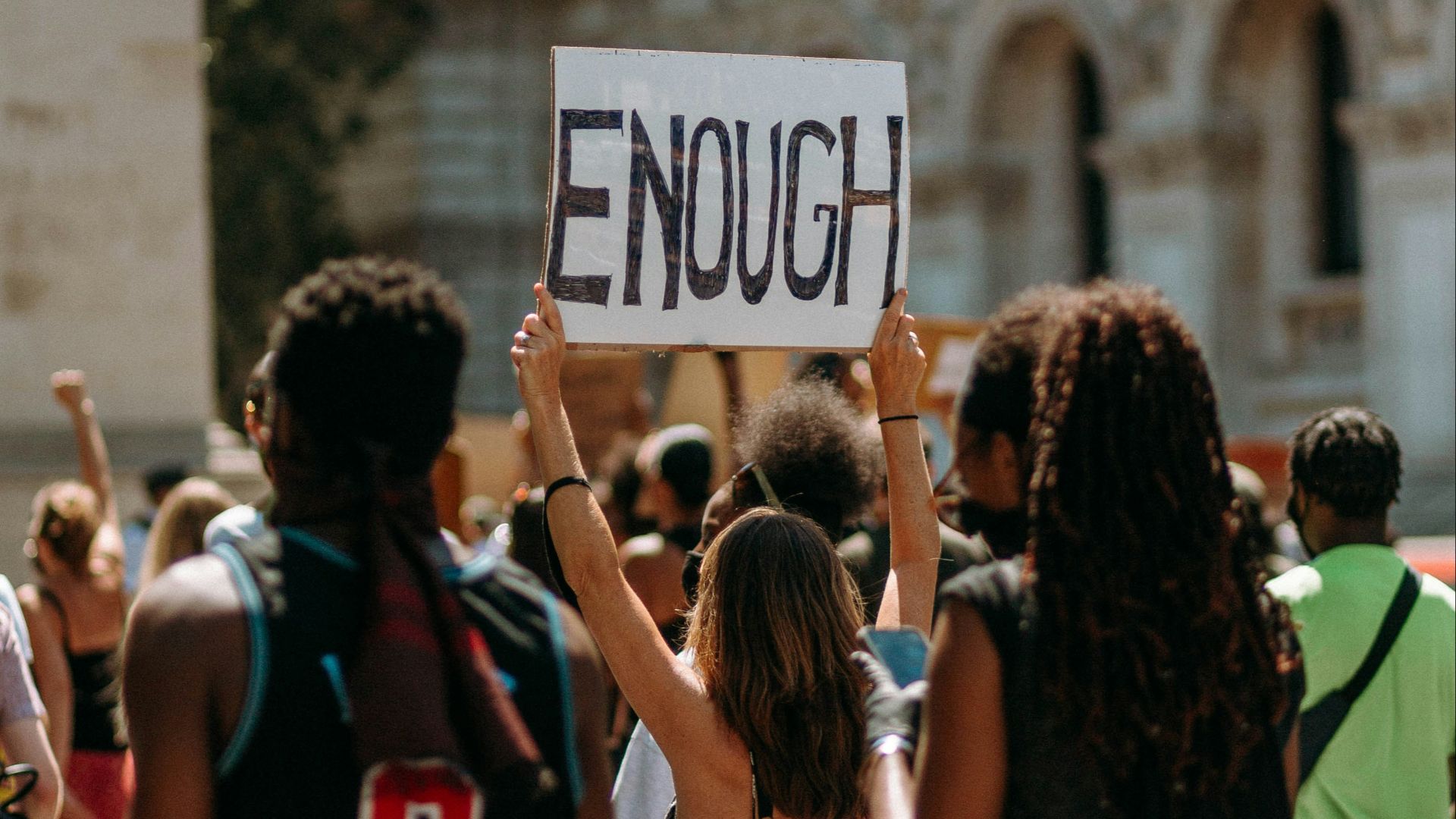 people holding a signage during daytime