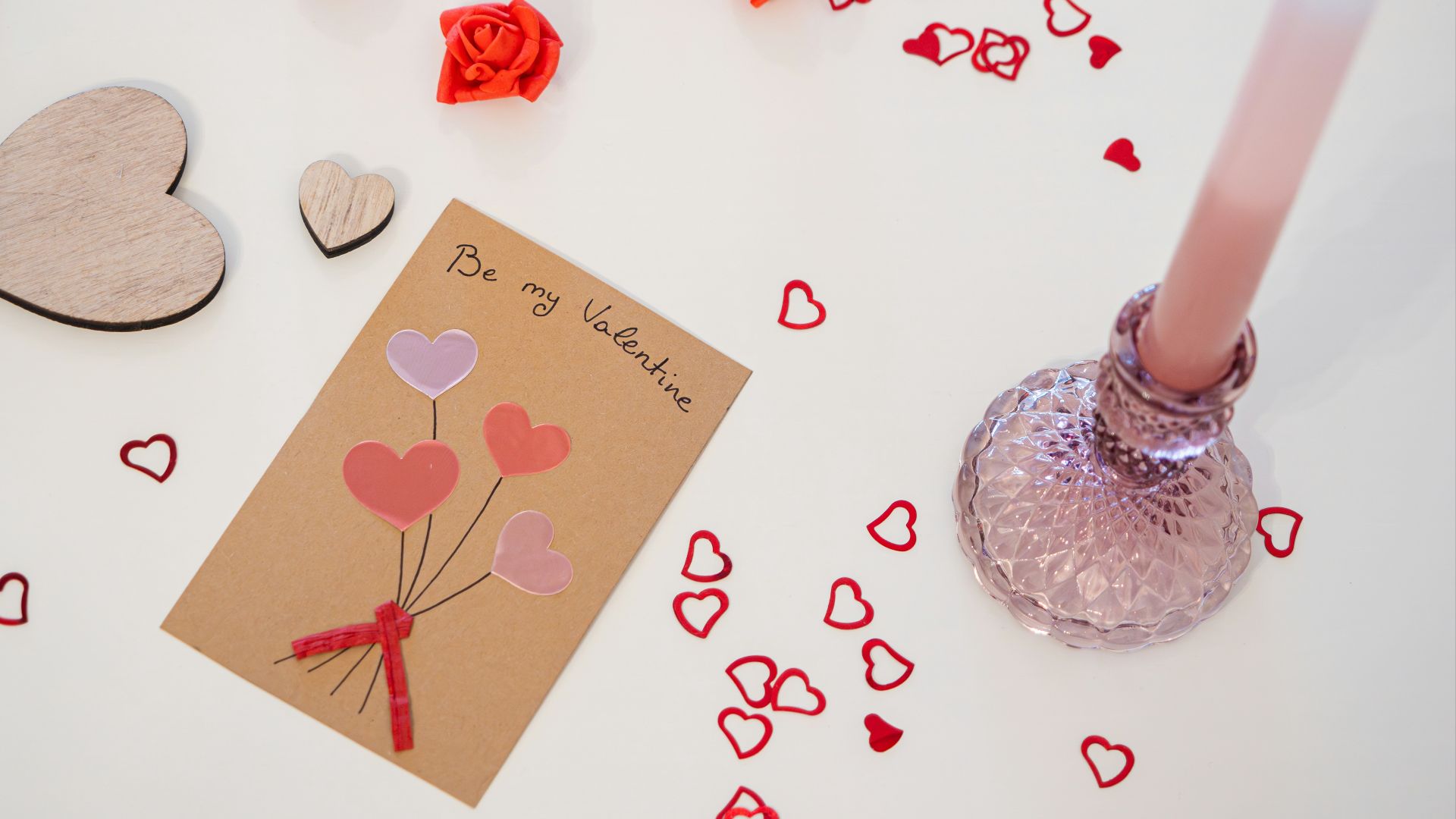 a valentine's day card and a candle on a table