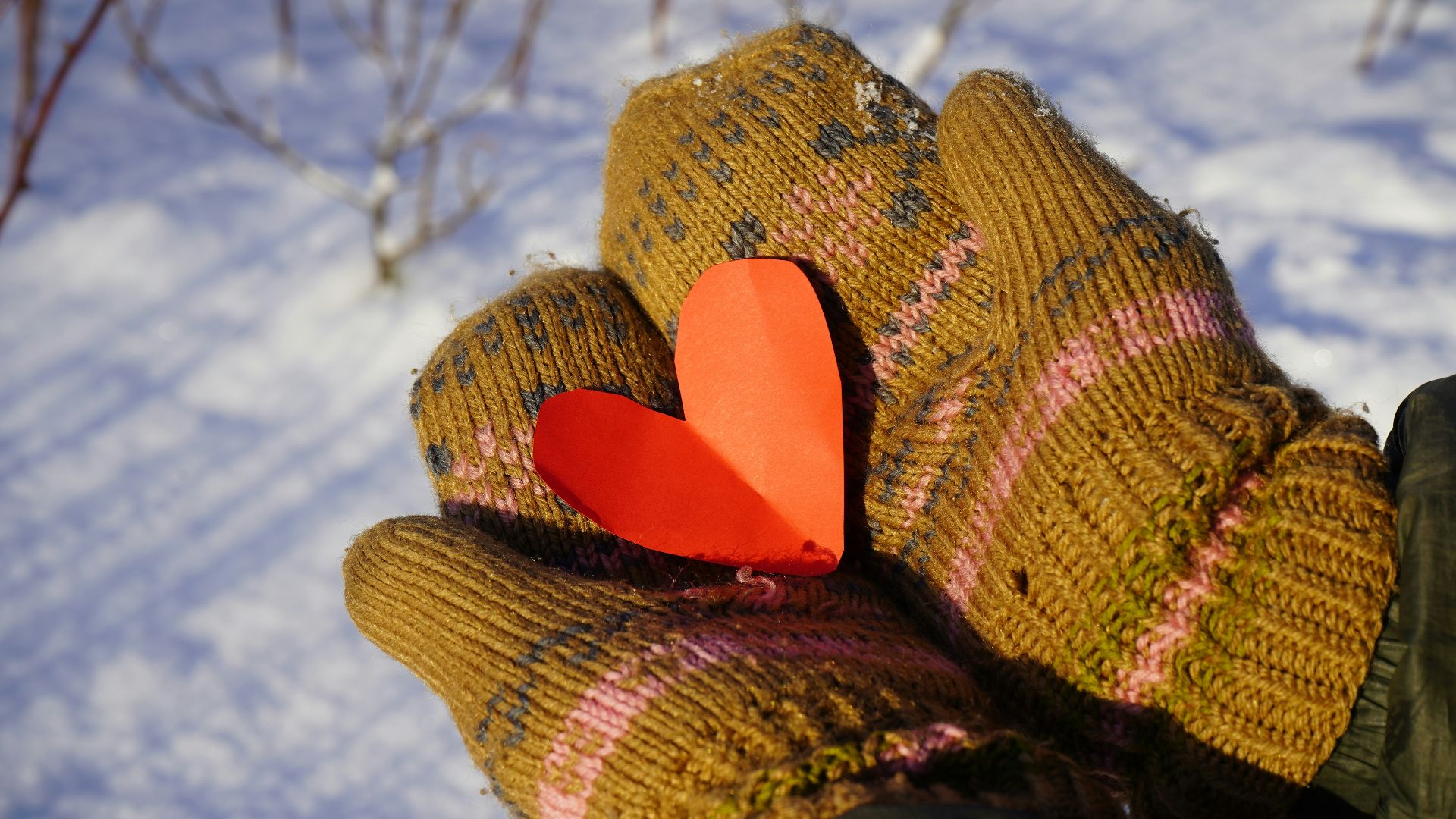 a glove with a heart on it in the snow