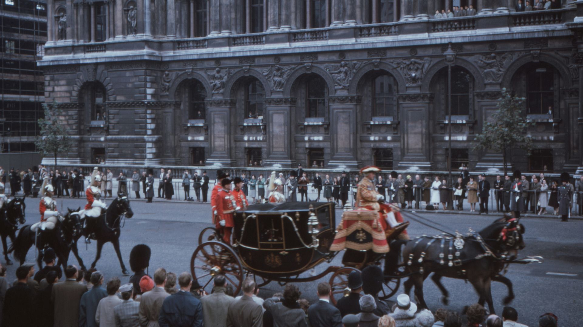 people sitting on black metal chairs near gray concrete building during daytime