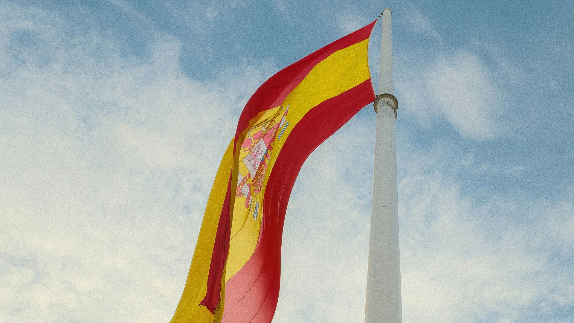 a red and yellow flag flying in the wind
